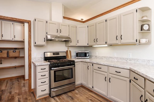 810 Capman St, Milton, WI 53563 - kitchen with appliances with stainless steel finishes, under cabinet range hood, open shelves, wood finished floors, and ornamental molding