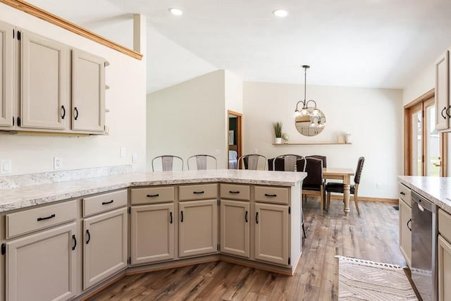 810 Capman St, Milton, WI 53563 - kitchen featuring a peninsula, stainless steel dishwasher, a chandelier, wood finished floors, and decorative light fixtures