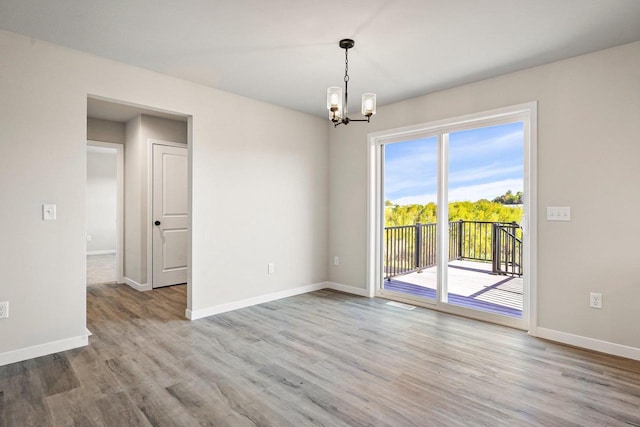 N6220 Blarney Stone Dr Unit 53, Albany, WI 53520 - unfurnished room with a chandelier and wood finished floors