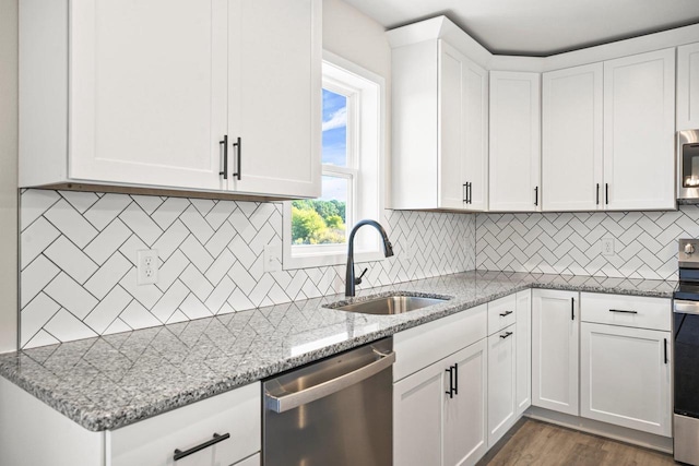 N6220 Blarney Stone Dr Unit 53, Albany, WI 53520 - kitchen with stainless steel appliances, light stone countertops, white cabinets, tasteful backsplash, and dark wood-style floors