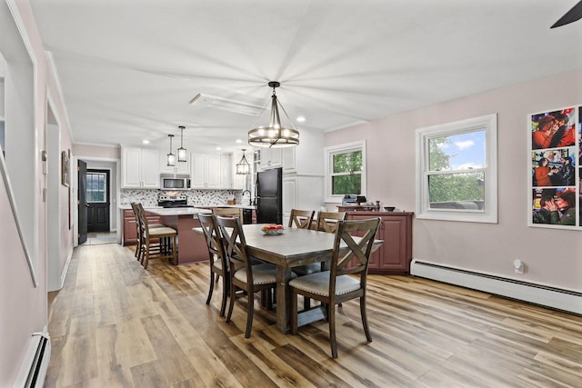 521 Maunesha Dr, Marshall, WI 53559 - dining room with baseboard heating, light wood finished floors, recessed lighting, a baseboard radiator, and a chandelier