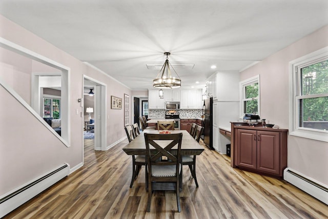 521 Maunesha Dr, Marshall, WI 53559 - dining space with a baseboard heating unit, light wood-style floors, recessed lighting, and a chandelier