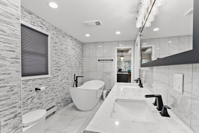 521 Maunesha Dr, Marshall, WI 53559 - bathroom featuring tile walls, a freestanding bath, double vanity, baseboard heating, and recessed lighting