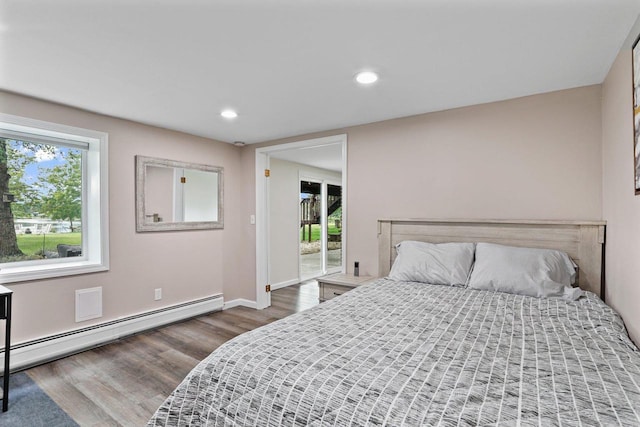 521 Maunesha Dr, Marshall, WI 53559 - bedroom featuring wood finished floors, a baseboard heating unit, access to exterior, and recessed lighting