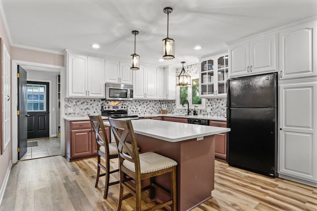 521 Maunesha Dr, Marshall, WI 53559 - kitchen with black appliances, healthy amount of natural light, light wood finished floors, a kitchen breakfast bar, and recessed lighting