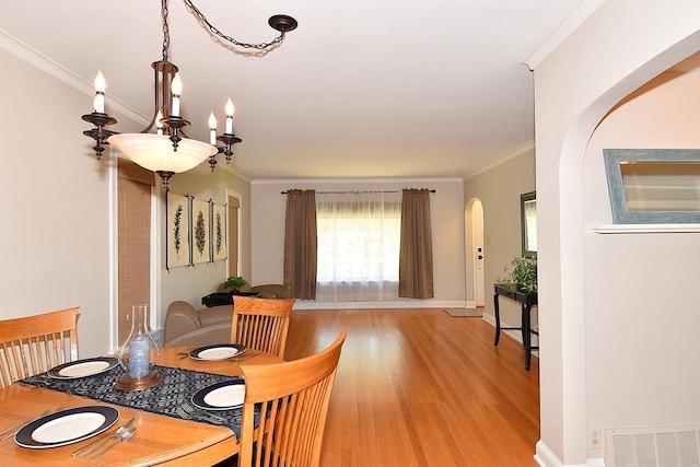 2744 N Lefeber Ave, Wauwatosa, WI 53210 - dining area featuring arched walkways, light wood-type flooring, and ornamental molding