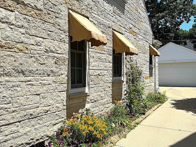 2744 N Lefeber Ave, Wauwatosa, WI 53210 - view of side of home featuring stone siding, a detached garage, and an outdoor structure