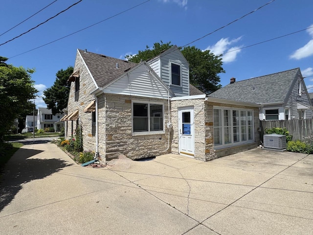 2744 N Lefeber Ave, Wauwatosa, WI 53210 - rear view of house with stone siding, a patio, and roof with shingles