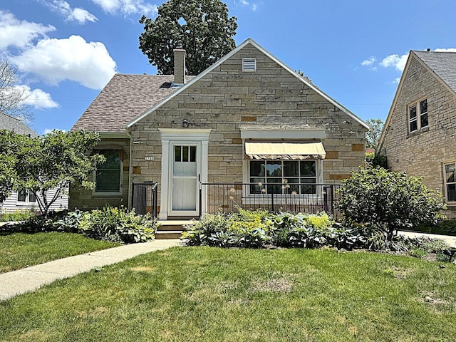 2744 N Lefeber Ave, Wauwatosa, WI 53210 - view of front of home featuring a front yard, stone siding, a chimney, and roof with shingles