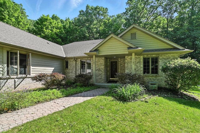 520 Bayberry Ln, Slinger, WI 53086 - single story home with brick siding, a front yard, a porch, and a shingled roof