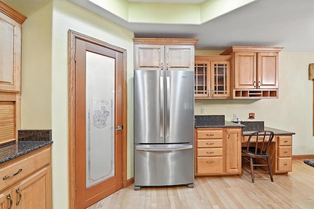 520 Bayberry Ln, Slinger, WI 53086 - kitchen with freestanding refrigerator, light wood-style flooring, glass insert cabinets, dark stone countertops, and built in study area