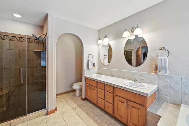 520 Bayberry Ln, Slinger, WI 53086 - bathroom with double vanity, a tile shower, and tile patterned flooring