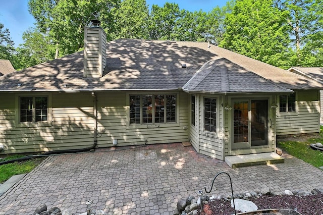 520 Bayberry Ln, Slinger, WI 53086 - back of property featuring a patio area, roof with shingles, and a chimney