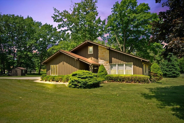 1075 E Murray Ln, Hubertus, WI 53033 - view of front of home featuring a storage shed, a lawn, and board and batten siding