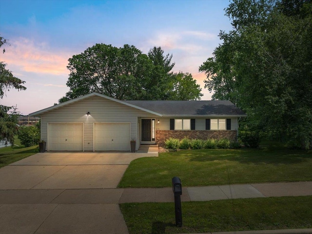 615 N Peach Ave, Marshfield, WI 54449 - ranch-style home with an attached garage, a front lawn, driveway, and brick siding