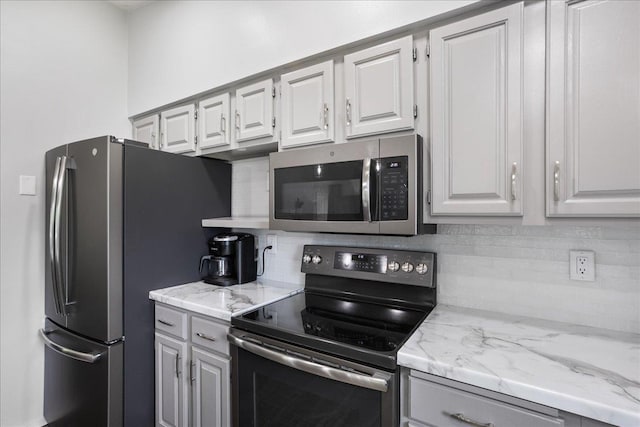 615 N Peach Ave, Marshfield, WI 54449 - kitchen featuring stainless steel appliances, tasteful backsplash, light stone counters, and white cabinetry