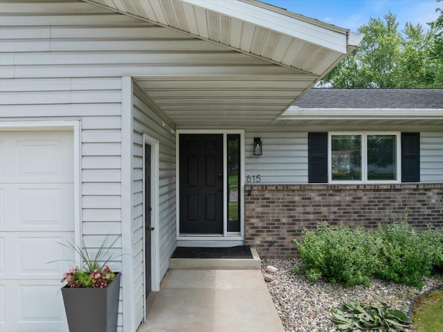 615 N Peach Ave, Marshfield, WI 54449 - property entrance with brick siding, a garage, and roof with shingles