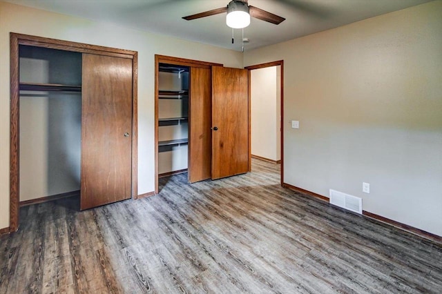 5716 Sauk Ln, Mcfarland, WI 53558 - unfurnished bedroom with multiple closets, wood finished floors, and ceiling fan