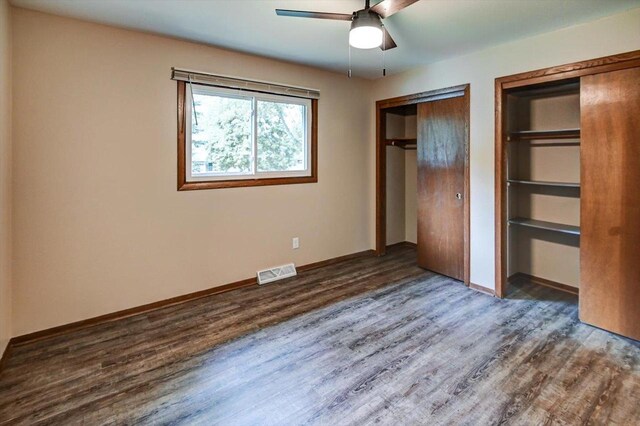 5716 Sauk Ln, Mcfarland, WI 53558 - unfurnished bedroom featuring wood finished floors, two closets, and a ceiling fan