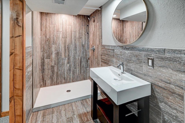5716 Sauk Ln, Mcfarland, WI 53558 - bathroom with a stall shower, tile walls, vanity, and wainscoting