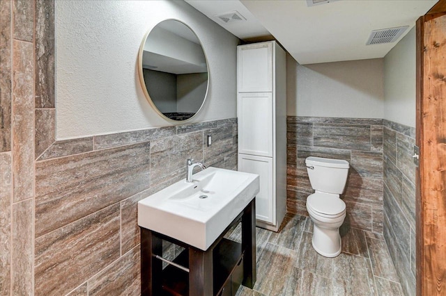 5716 Sauk Ln, Mcfarland, WI 53558 - half bathroom with tile walls, wainscoting, vanity, and wood finished floors