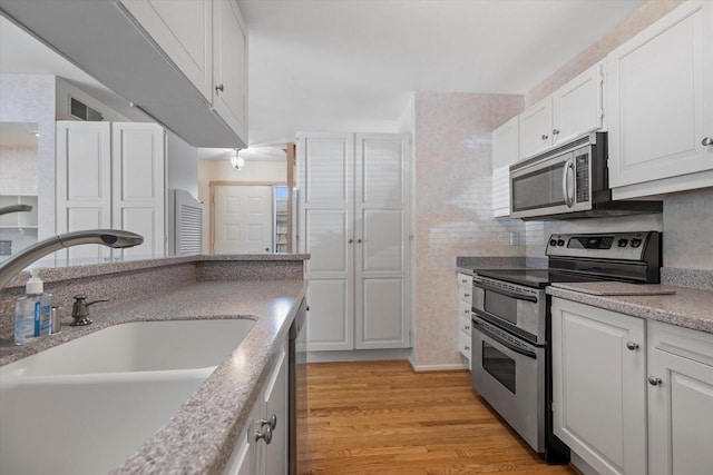 36 Stonewood Ct Unit 36, Wind Point, WI 53402 - kitchen featuring stainless steel appliances, white cabinets, and light wood-style flooring