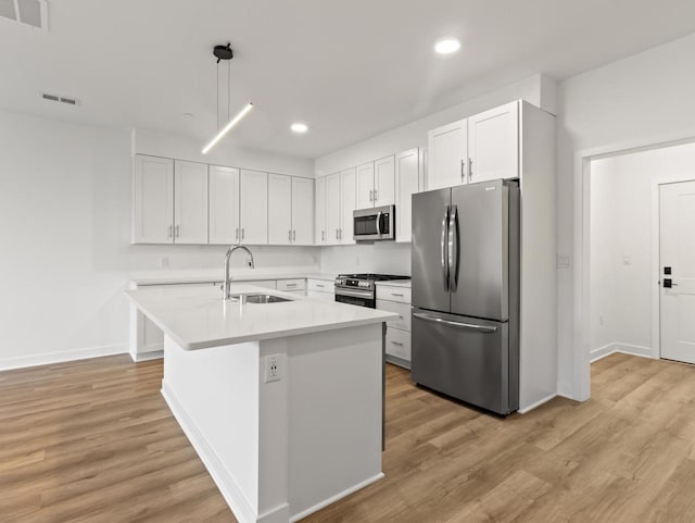 9352 S Alder Pl Unit 105, Oak Creek, WI 53154 - kitchen with appliances with stainless steel finishes, light wood finished floors, recessed lighting, light countertops, and a center island with sink