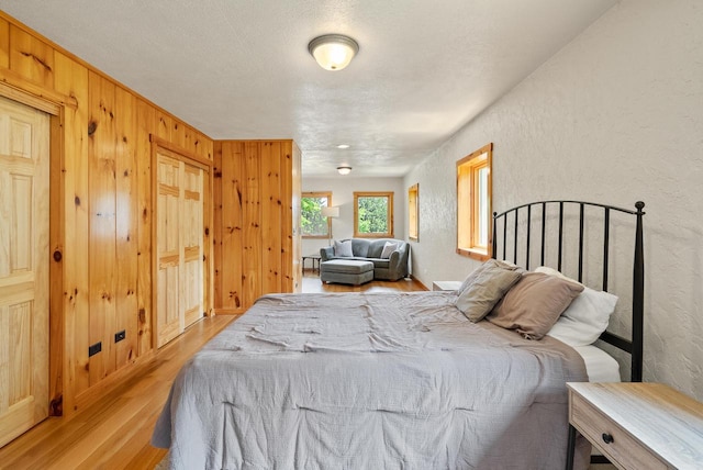 N3245 Walnut Rd, Lake Geneva, WI 53147 - bedroom featuring light wood finished floors, a textured wall, and wooden walls