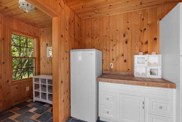 1948 Field Cliffe Dr, Richfield, WI 53076 - kitchen with freestanding refrigerator, wooden ceiling, tile countertops, and wooden walls
