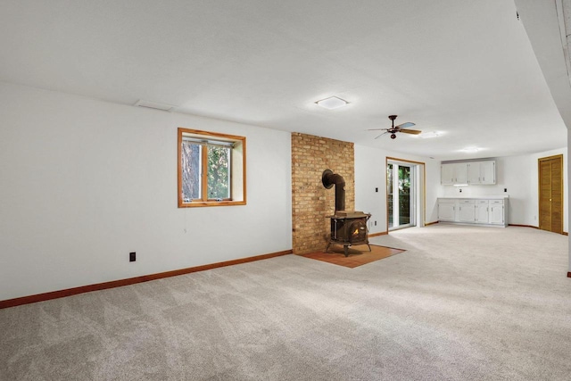 2806 Mckenna Blvd, Madison, WI 53719 - unfurnished living room with a wood stove, light carpet, and a ceiling fan