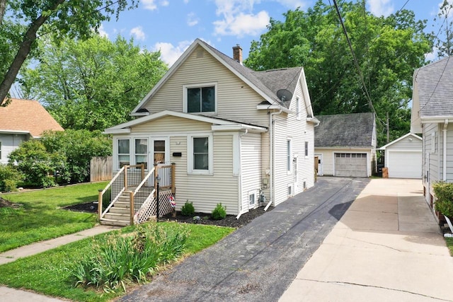 911 W Bent Ave, Oshkosh, WI 54901 - view of front of house with an outbuilding, a detached garage, a front yard, a chimney, and a shingled roof