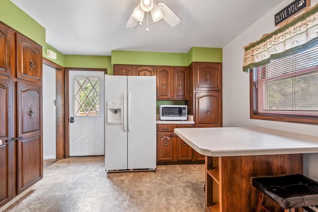 911 W Bent Ave, Oshkosh, WI 54901 - kitchen featuring white appliances, light countertops, a kitchen breakfast bar, a peninsula, and ceiling fan
