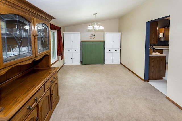 1882 Davis Ln, Waukesha, WI 53189 - foyer entrance featuring light carpet, vaulted ceiling, and a chandelier