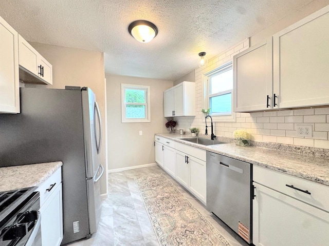 229 Bacon Ave, Oshkosh, WI 54901 - kitchen featuring appliances with stainless steel finishes, decorative backsplash, white cabinets, and a textured ceiling