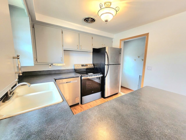 2518 Main Ave, Sheboygan, WI 53083 - kitchen featuring appliances with stainless steel finishes, light wood-style flooring, dark countertops, and gray cabinets
