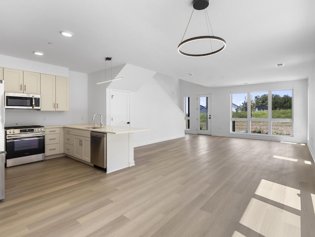 4199 E Hemlock Dr Unit 108, Oak Creek, WI 53154 - kitchen featuring appliances with stainless steel finishes, a peninsula, light wood-style flooring, open floor plan, and recessed lighting