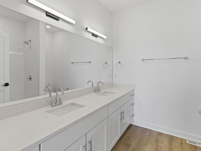 4199 E Hemlock Dr Unit 108, Oak Creek, WI 53154 - bathroom featuring double vanity, wood finished floors, and a tile shower