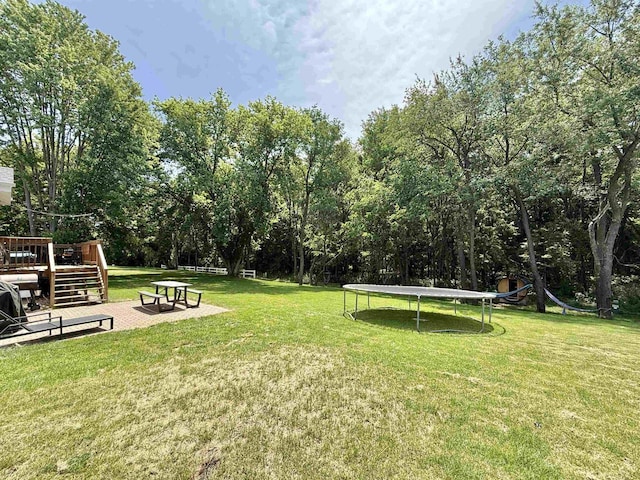 2324 Boulder Ln, Beloit, WI 53511 - view of grassy yard featuring a trampoline and a deck