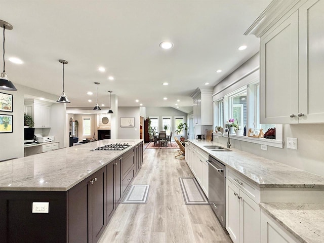 2324 Boulder Ln, Beloit, WI 53511 - kitchen featuring appliances with stainless steel finishes, open floor plan, light wood-type flooring, a large island, and white cabinets
