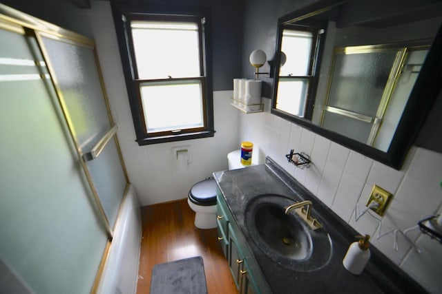 6818 W Morgan Ave, Milwaukee, WI 53220 - bathroom with vanity, wood finished floors, decorative backsplash, and combined bath / shower with glass door