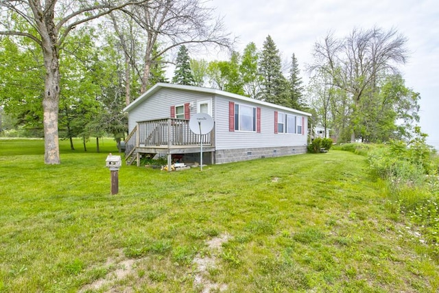 N3688 M-35, Menominee, MI 49858 - view of front of home with a wooden deck, a front yard, crawl space, and view of wooded area