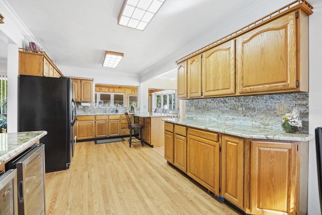 442 E Richardson Springs Rd, Edgerton, WI 53534 - kitchen with freestanding refrigerator, light wood finished floors, decorative backsplash, beverage cooler, and light stone countertops