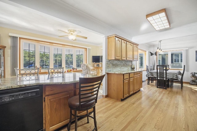 442 E Richardson Springs Rd, Edgerton, WI 53534 - kitchen with black dishwasher, crown molding, a breakfast bar, light stone countertops, and light wood finished floors