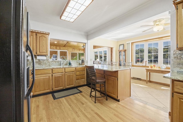442 E Richardson Springs Rd, Edgerton, WI 53534 - kitchen featuring freestanding refrigerator, ceiling fan, light wood-style flooring, a peninsula, and crown molding