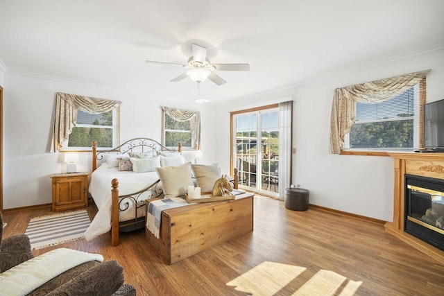 442 E Richardson Springs Rd, Edgerton, WI 53534 - bedroom with access to outside, crown molding, wood finished floors, a glass covered fireplace, and ceiling fan
