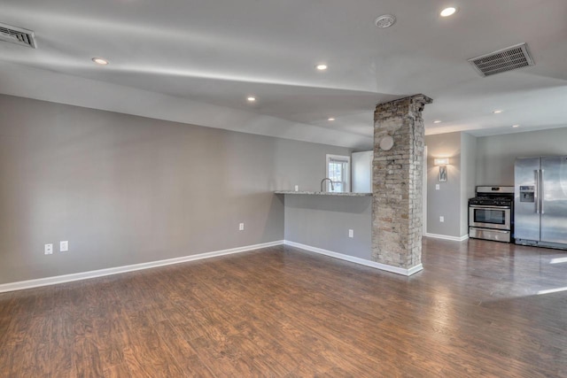 1626 N Warren Ave, Milwaukee, WI 53202 - unfurnished living room featuring dark wood-style floors, decorative columns, and recessed lighting