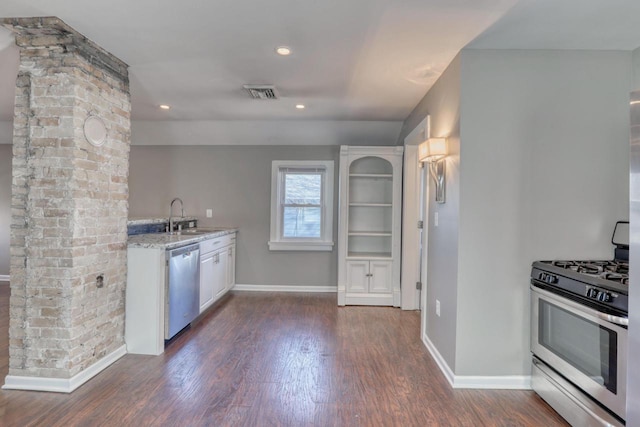 1626 N Warren Ave, Milwaukee, WI 53202 - kitchen with appliances with stainless steel finishes, dark wood-style floors, light stone countertops, white cabinetry, and recessed lighting