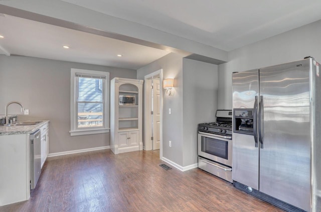 1626 N Warren Ave, Milwaukee, WI 53202 - kitchen with appliances with stainless steel finishes, dark wood-style floors, white cabinetry, light stone counters, and recessed lighting