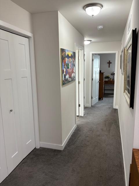 1965 N Windsor Ave, Cottage Grove, WI 53527 - hallway featuring dark colored carpet and baseboards