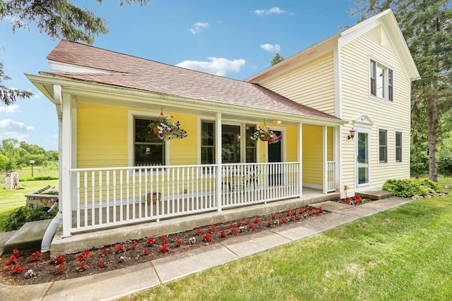 N64W20755 Mill Rd, Menomonee Falls, WI 53051 - view of front of property with covered porch, a front yard, and roof with shingles